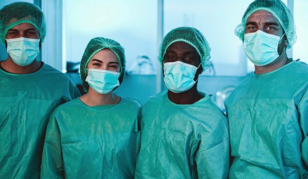 Medical workers inside hospital laboratory during coronavirus pandemic outbreak - Doctor and nurse at work on Covid-19 crisis period - Healthcare concept - Main focus on african man face